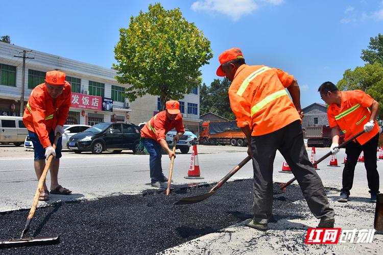 7月25日,公路养护人员冒着36摄氏度的高温对浏大公路进行路面修补.