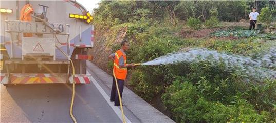 1大足公路养护中心工人为辖区公路沿线花草浇水解渴。特约通讯员 蒋文友 摄